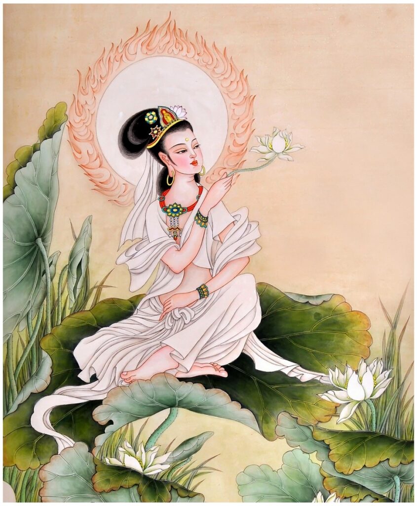 As seen in this illustration, Kannon wears gold jewelry and a white robe while sitting on grass, admiring a flower.  